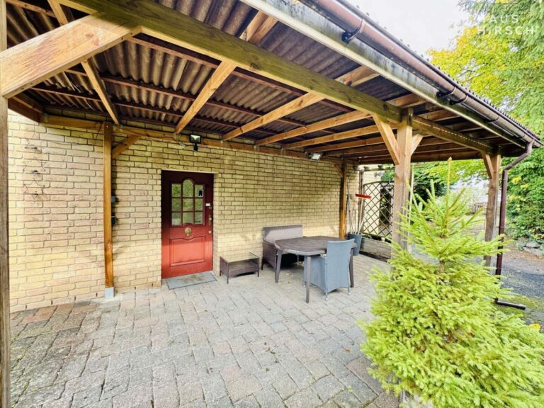 Einladender Hauseingang mit überdachtem Sitzbereich