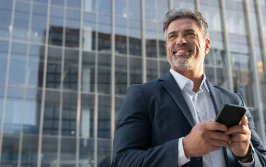 A Man In A Suit Holding A Phone