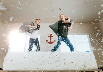 two boys fighting with pillows