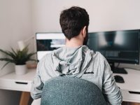 a man sitting in a chair looking at a computer screen