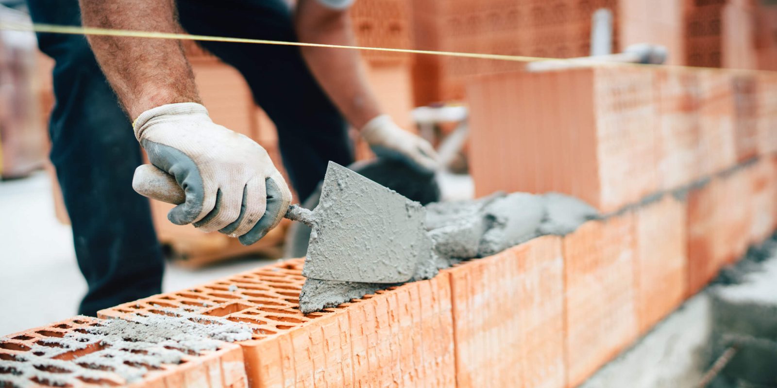 a person using a trowel to lay bricks