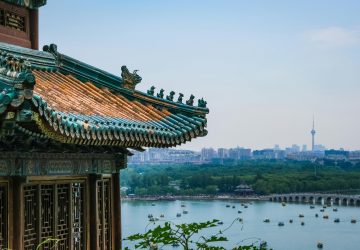 a building with a body of water and a city in the background